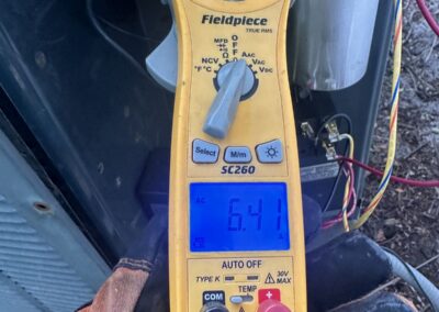 Technician testing a failed AC capacitor with a meter at a Lake Charleston, Greenacres condenser