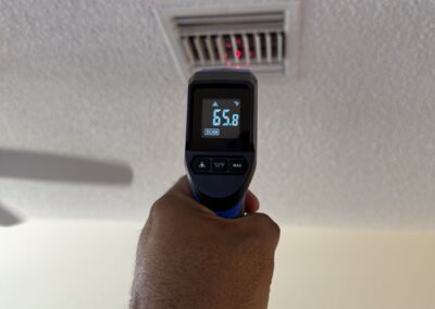 Infrared thermometer reading supply air at a ceiling vent in Bent Tree Villas, Boynton Beach