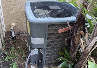 Older Goodman outdoor AC unit beside a home in Lake Charleston, Lake Worth, before a no-cool diagnostic