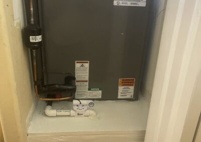 New Rheem air handler on an elevated stand with a secondary drain pan in a Nautica Sound closet, Boynton Beach