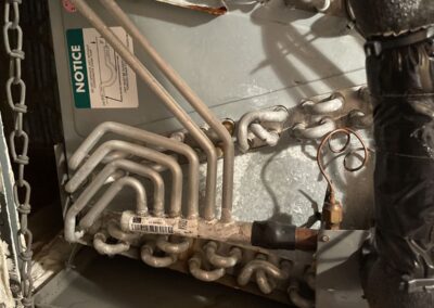 Evaporator coil and refrigerant lines inside an air handler during an AC tune-up in Manor Forest, Boynton Beach