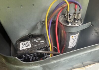 Dual run capacitor and wiring in an outdoor AC unit checked during maintenance in West Palm Beach