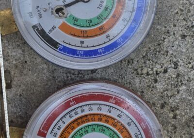 Refrigerant manifold gauges on an outdoor AC unit during a tune-up in West Palm Beach