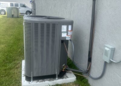 New outdoor condenser on a pad beside a commercial building in the Lake Worth area