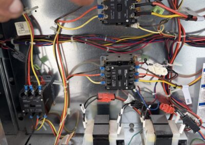 Technician pointing to a failed relay on a 3-phase air conditioning control panel in Coral Springs