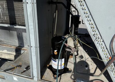 Open rooftop package unit showing the compressor during a replacement in Boca Raton