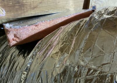 Large insulated flex supply duct supported on lumber below a roof truss in a Boynton Beach attic